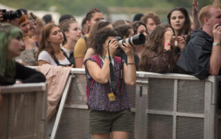 Concertfotograaf vangt een energiek moment van een zanger op het podium, met fel podiumlicht dat de intensiteit van het optreden benadrukt.