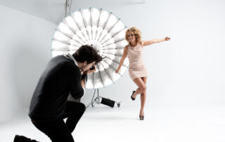 Modefotograaf werkt met een model in een studio, waarbij de kleding perfect harmonieert met kleding en vrouw.