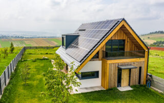 Een vastgoedfotograaf heeft een foto genomen van een vrijstaande boerderijwoning met zonnepanelen op het dak, wat duurzaamheid en landelijke charme combineert in een enkel beeld.