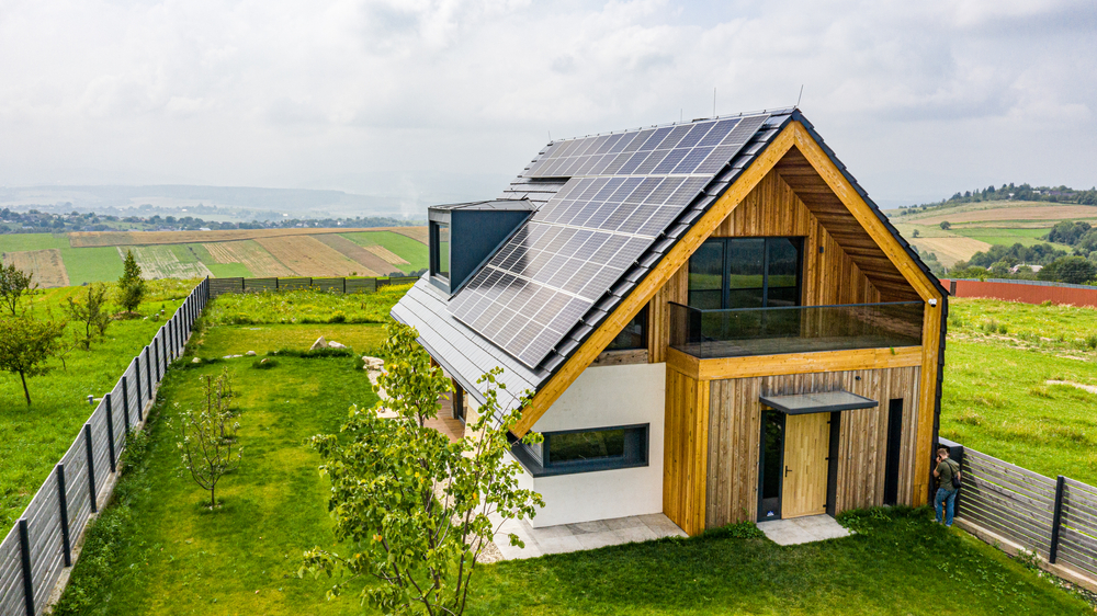 Een vastgoedfotograaf heeft een foto genomen van een vrijstaande boerderijwoning met zonnepanelen op het dak, wat duurzaamheid en landelijke charme combineert in een enkel beeld.