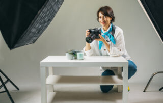Een close-up van een reclamefotografe die bij het product zit, gericht op het vastleggen van de perfecte compositie voor een reclamefoto, toont de toewijding aan het vak van reclamefotografie.