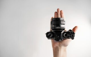Een afbeelding van een Spiegelloze camera in de hand van een fotograaf.