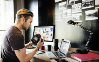 Een freelance fotograaf bekijkt aandachtig zijn camera terwijl hij zijn genomen foto's inspecteert, waardoor de professionaliteit en toewijding aan zijn vak worden benadrukt.