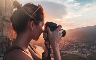Een professionele fotograaf die zorgvuldig een landschap vastlegt met een high-end digitale camera op een statief.