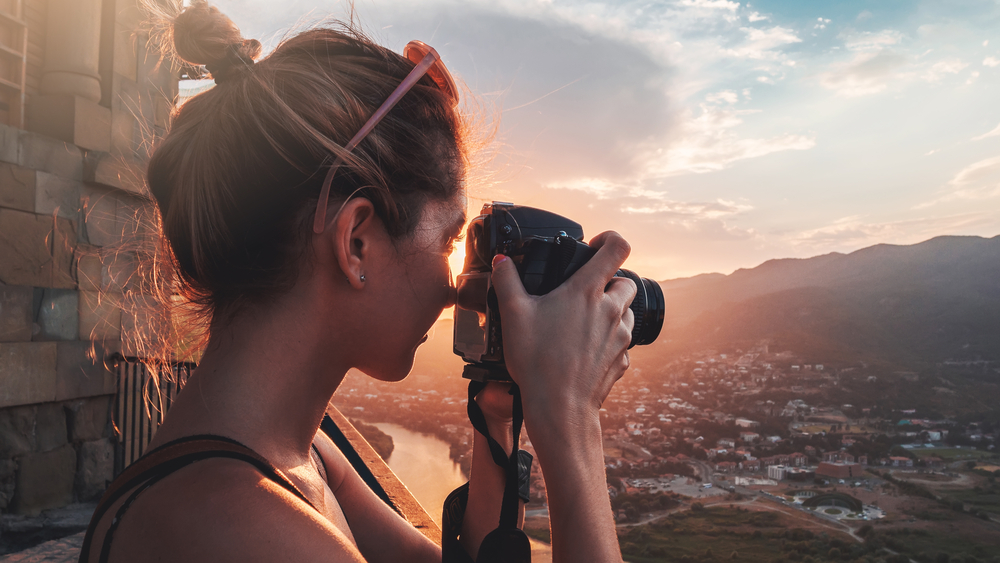 Een professionele fotograaf die zorgvuldig een landschap vastlegt met een high-end digitale camera op een statief.
