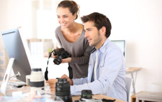 In een fotostudio bekijken een fotograaf en een fotografe een foto op het computerscherm, wat aangeeft dat ze de genomen foto's evalueren en bewerken om het beste resultaat te bereiken. Dit is een essentieel onderdeel van het fotografieproces om de beelden te optimaliseren voordat ze worden gepubliceerd of afgedrukt.