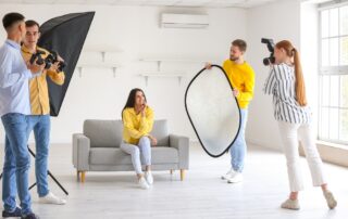 Een reflector wordt gebruikt tijdens een fotoshoot waarbij één persoon poseert. De reflector wordt strategisch geplaatst om het licht te sturen en de schaduwen op het onderwerp te verminderen, wat resulteert in een beter belichte en meer flatterende foto.