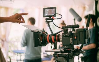 Een filmcamerateam in actie, compleet met een filmcamera. Het team is bezig met het opnemen van filmbeelden, met de camera in het middelpunt van de aandacht. Dit omvat meestal de cameraman, de regisseur, de belichtingscrew en andere leden die samenwerken om een filmproject te realiseren. De filmcamera wordt bediend om professionele opnamen te maken, en het team werkt samen om de visie van de regisseur tot leven te brengen.