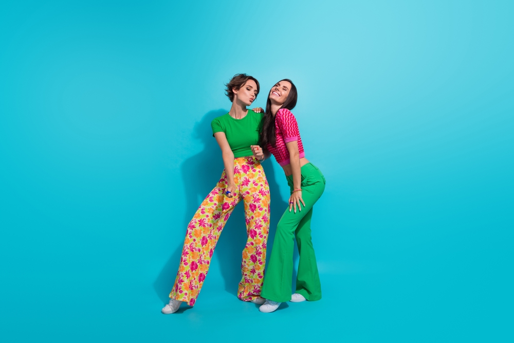 Professionele photoshoot waarbij zussen met elkaar aan het lachen zijn. Je ziet felle kleuren die prachtig op beeld komen.