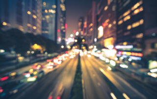 Een foto van stadslichten die met bokeh-effect zijn vastgelegd. In deze opname zijn de lichten van de stad onscherp en vormen ze prachtige bokeh-lichtvlekken. Dit resulteert in een sfeervolle en artistieke weergave van de stad 's nachts, waarbij de lichten een betoverend en onscherp patroon vormen. Bokeh wordt vaak gebruikt om een vleugje magie toe te voegen aan nachtfotografie.